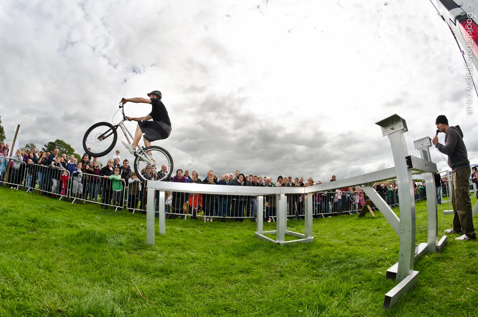 Technical bicycle stunt riding on an obstacle in front of an audience