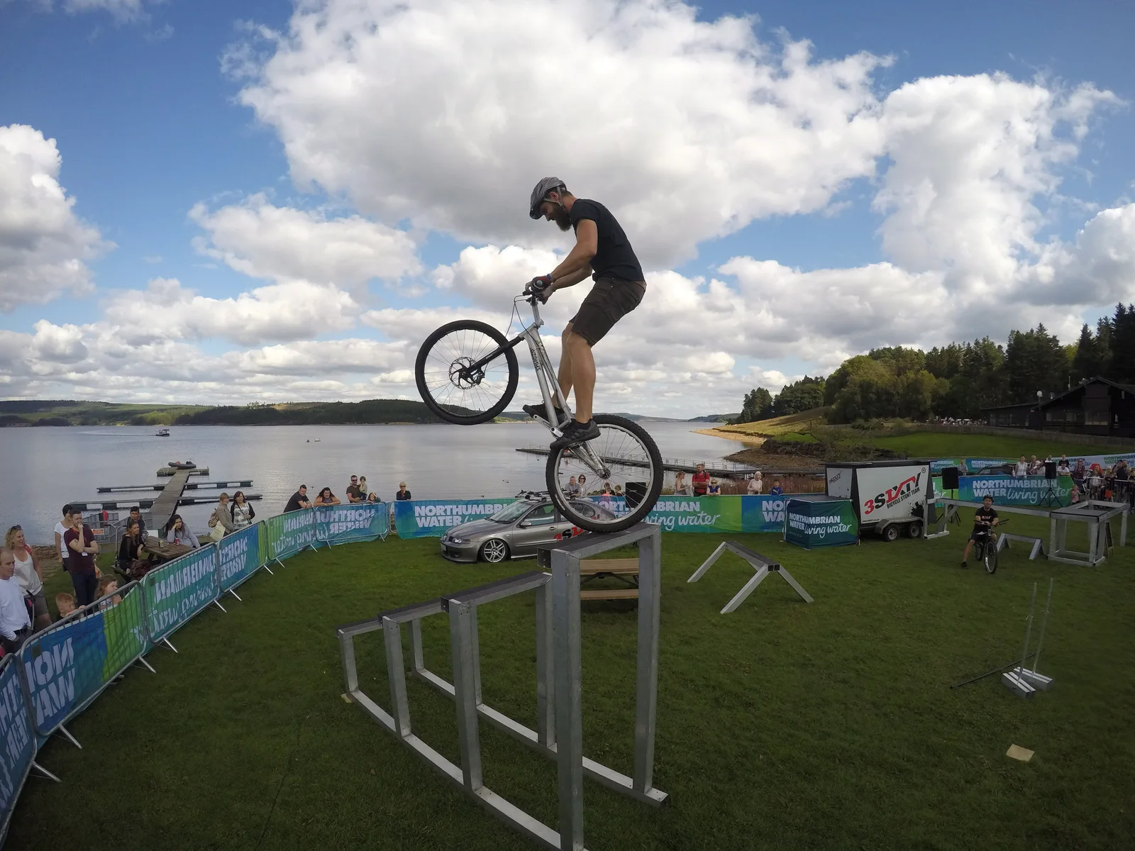 3SIXTY portable bicycle stunt setup at an outdoor event beside a lake